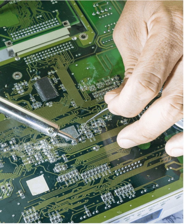 Mains travaillant sur une carte électronique