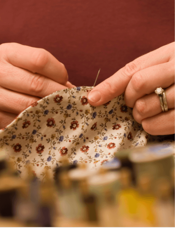 Mains travaillant le bois avec une règle et un crayon